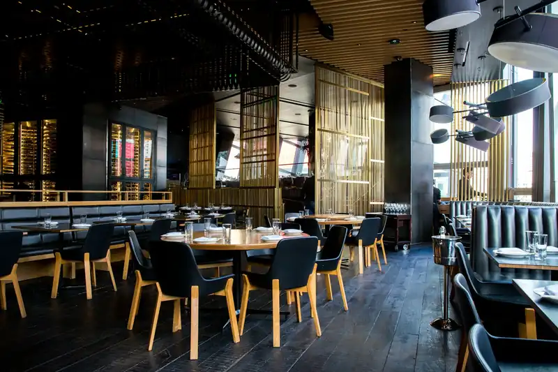 Modern restaurant dining room with timber tables and warm lighting